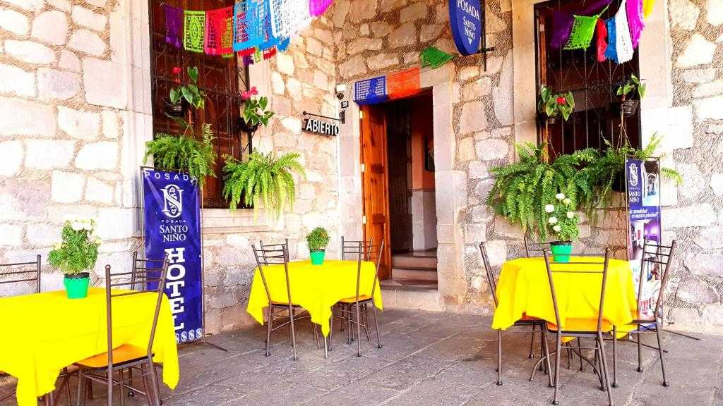 Stone entrance and colorful outdoor tables at Hotel Posada Santo Niño